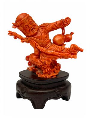 chinese carved figurine of a man holding a ball on a stand
