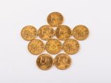 a pile of gold coins sitting on top of a white surface