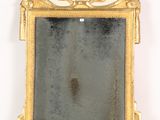 un cadre doré surmonté d'un miroir