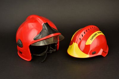 une paire de casques de pompier rouges et jaunes sur fond noir