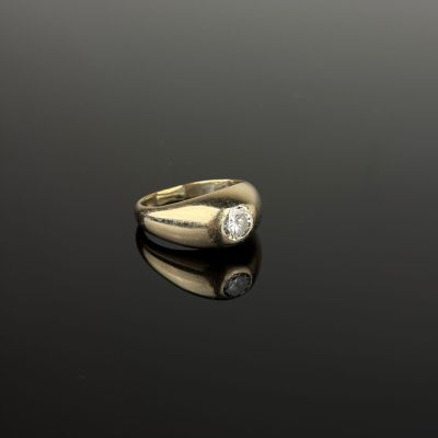 an image of a gold ring with two diamonds on a black surface