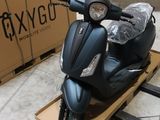 un scooter posé sur une palette devant une boîte