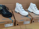 trois paires de chaussures posées sur des cartons