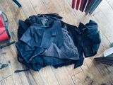 un tas de vêtements par terre, à côté d'un parapluie