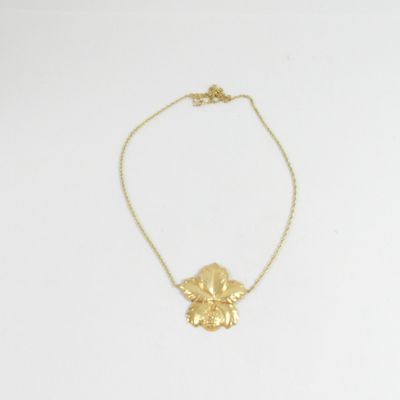 un collier plaqué or orné d'une fleur suspendue à une chaîne