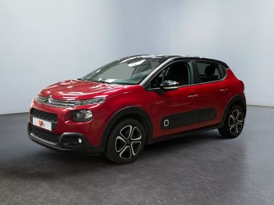 Une Citroën rouge est garée dans une pièce blanche