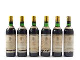 six bouteilles de vin sont alignées sur une surface blanche