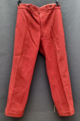 un pantalon rouge suspendu à un cintre accroché au mur