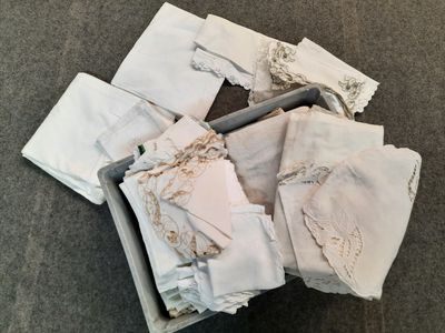 a box full of folded white cloths on the floor