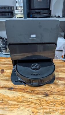 a laptop sitting on top of a cd player on a wooden table