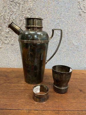 un pichet en métal et une tasse posés sur une table en bois