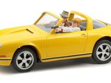 yellow toy car with two people in it on a white background