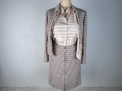 a mannequin with a dress and jacket on a mannequin stand