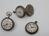 three different types of pocket watches are displayed on a white surface