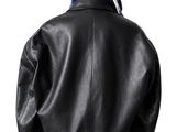 the back view of a woman wearing a black leather jacket and a pink skirt