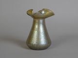 a silver vase with a curved handle on a table