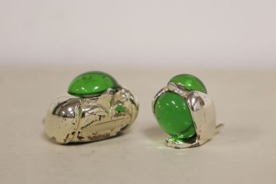pair of green glass and silver earrings on a white surface