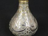 a silver vase with a gold decoration on it