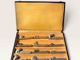 six knives in a case on a white surface