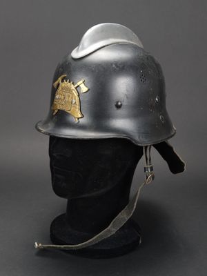 un vieux casque orné d'un emblème doré, posé sur la tête d'un mannequin