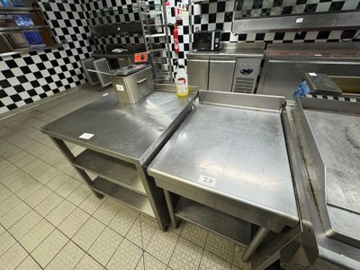 three stainless steel tables in a kitchen with checkered walls