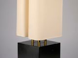 une lampe de table noire surmontée d'un abat-jour blanc