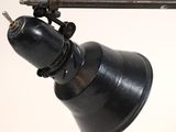 a black lamp that is on a white wall