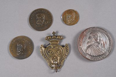 five coins and a medal on a table next to a coin