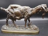 bronze statue of a goat with a baby goat in its mouth