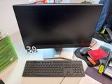 un écran d'ordinateur et un clavier posés sur un bureau dans un bureau à domicile