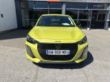the front of a yellow car parked in front of a building