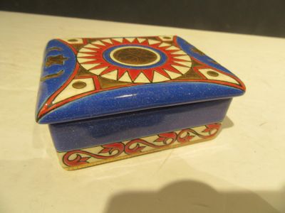 une boîte bleue et rouge ornée d'un motif représentant un soleil