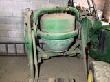 une machine verte qui se trouve à côté d'un tracteur vert
