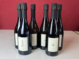 quatre bouteilles de vin sont alignées sur un comptoir
