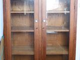 a large wooden cabinet with glass doors in a room