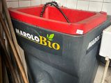 une poubelle rouge et noire posée dans un coin d'une pièce