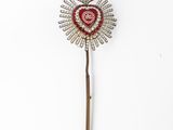 an image of a red heart shaped brooch on a stick
