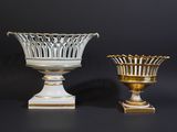 pair of white and gold vases on pedestals against a black background