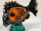 a figurine of a fish on a green base