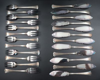 many forks and spoons laid out on a table