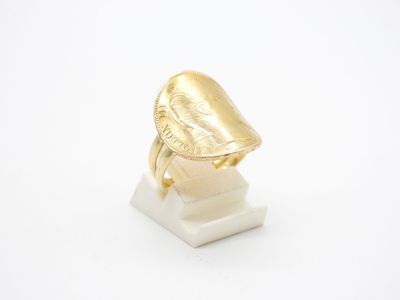 gros plan d'une bague en or sur une surface blanche