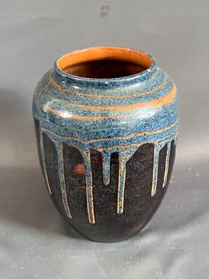 un vase bleu et orange posé sur une table