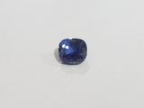 a blue sapphire stone on a white surface