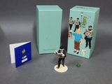 a figurine of a man standing next to a box of books