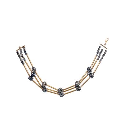 un collier noir et doré sur fond blanc