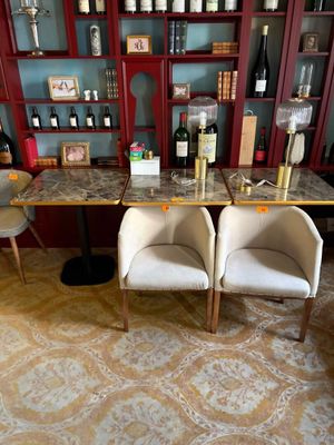 deux chaises placées devant une table sur laquelle sont posées des bouteilles de vin