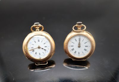 deux horloges posées sur une table, sur fond noir