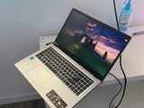 un ordinateur portable posé sur un bureau, à côté d'une bouteille d'eau