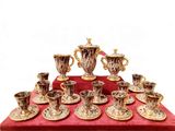 many cups and saucers on a red table cloth