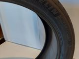 a close up of a tire on a wooden stand on a white surface